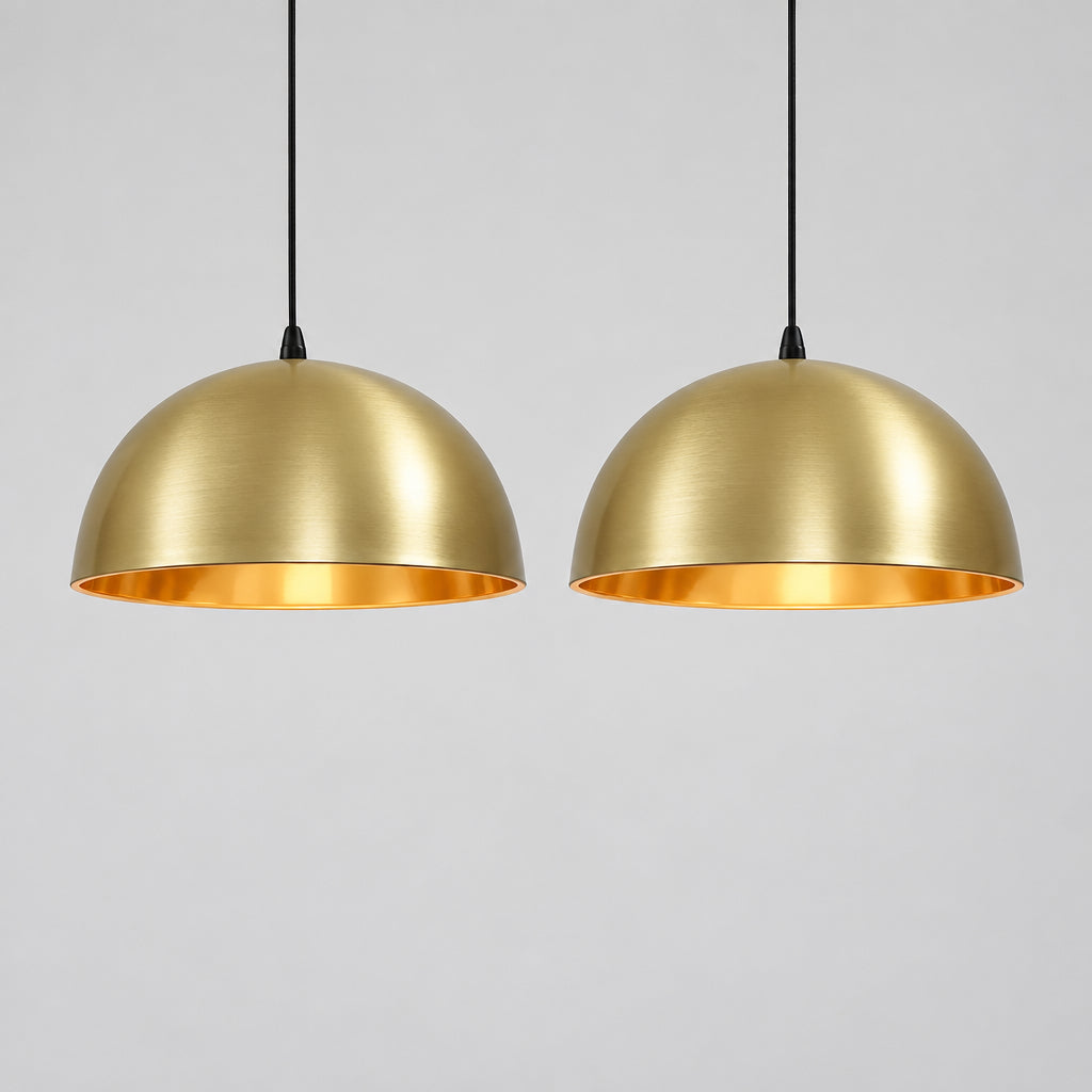 a modern kitchen with a large, white island and two gold pendant lights hanging above it.