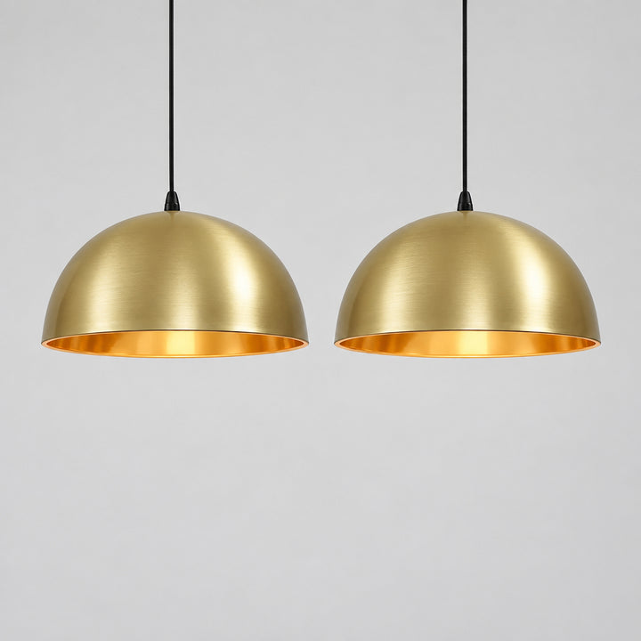 a modern kitchen with a large, white island and two gold pendant lights hanging above it.