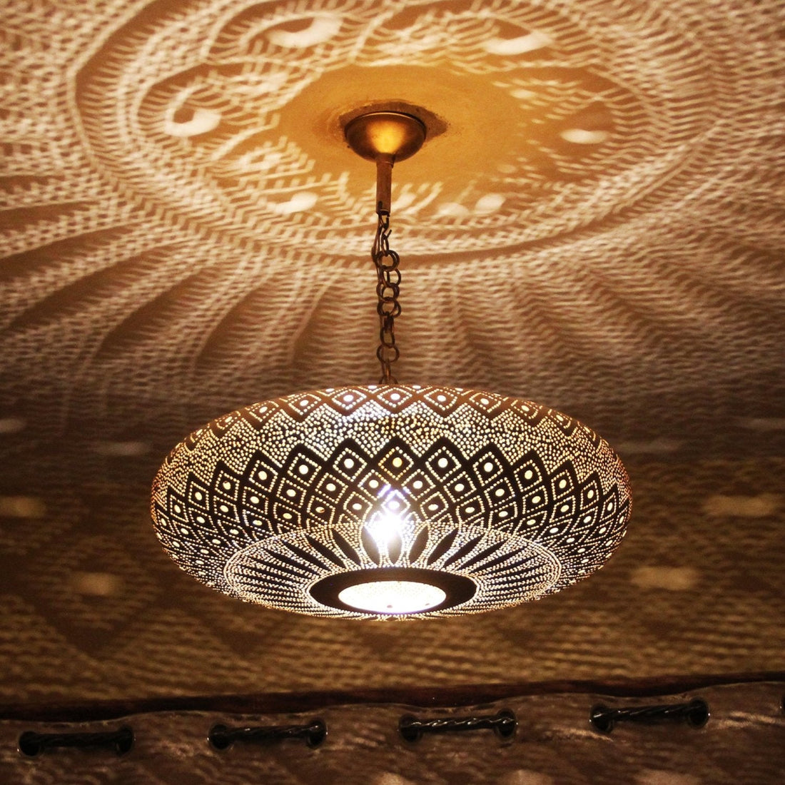 Handcrafted Moroccan brass pendant light with geometric cutout dome design

