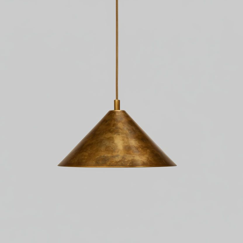 A single, gold-colored pendant light hangs from the ceiling against a beige wall.