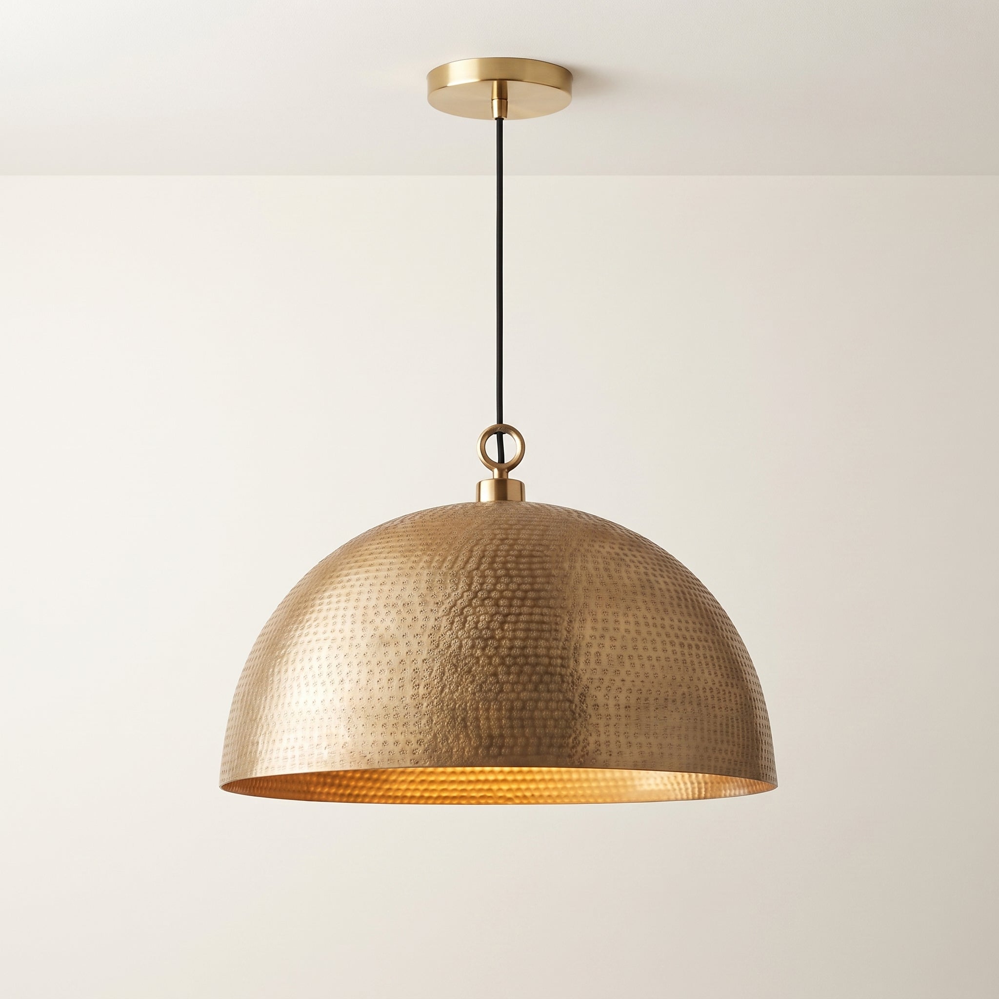 Hammered brass dome pendant light with warm golden finish and rounded shade