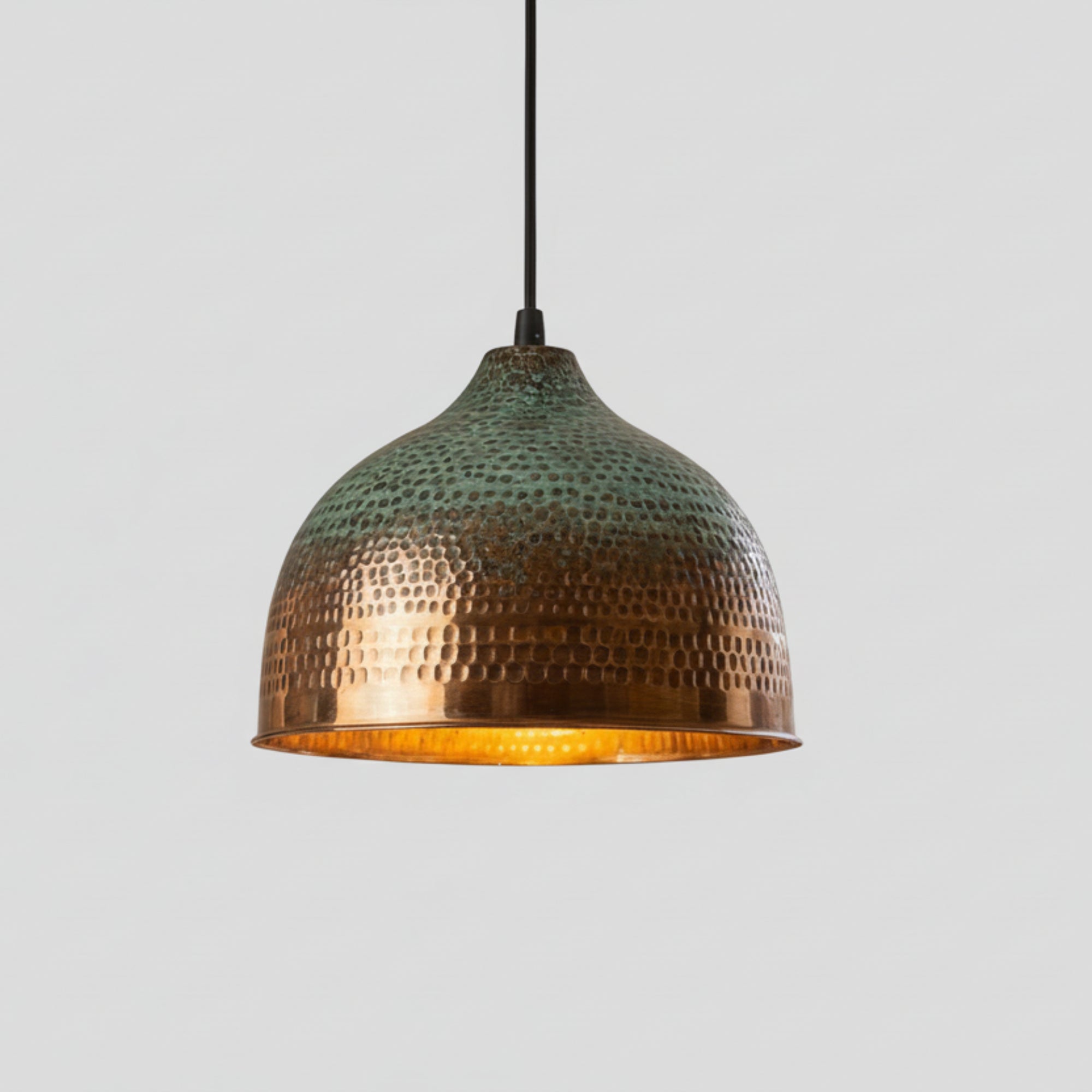 Hammered copper pendant light with green patina and rounded dome shade