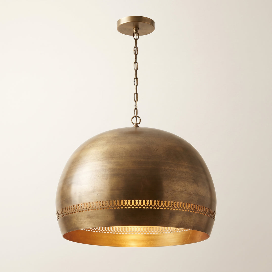 Perforated brass dome pendant light with antique finish and decorative pierced bands