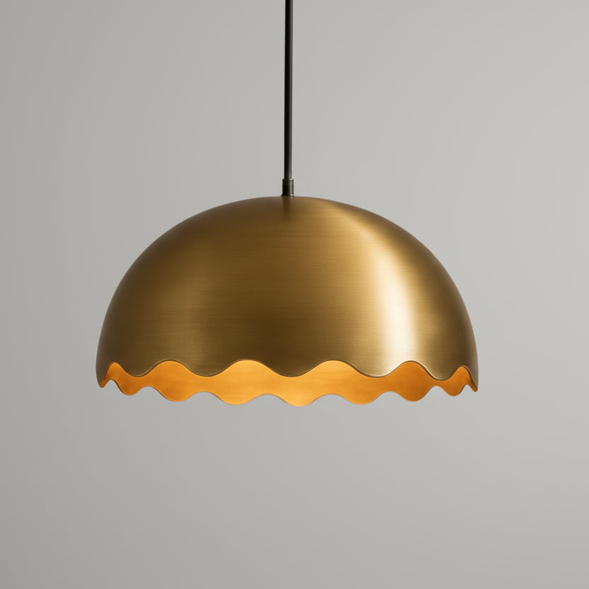 A gold-colored pendant light with a scalloped edge is suspended from the ceiling.