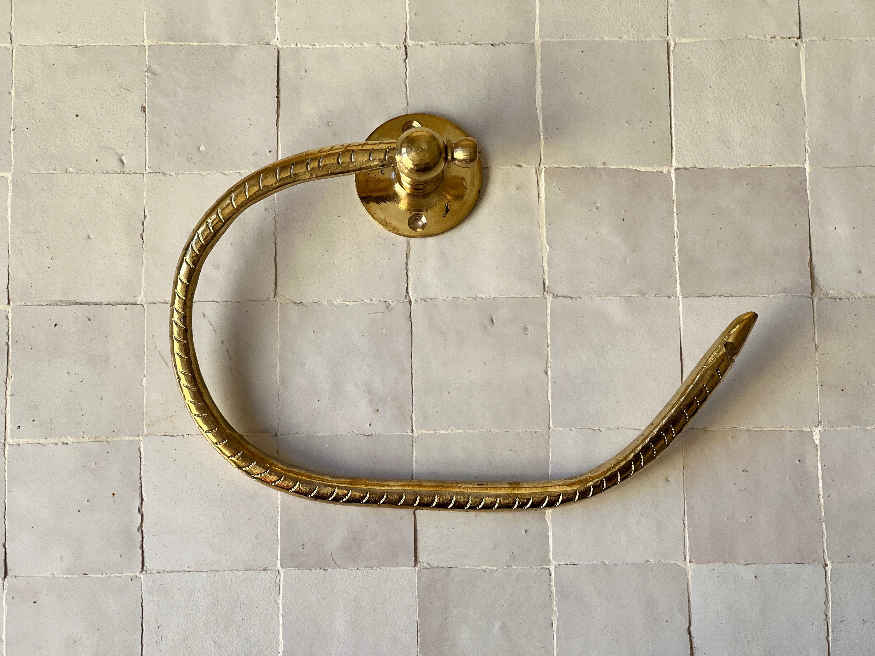 Elegant brass toilet paper holder with open-ended design for modern bathroom decor