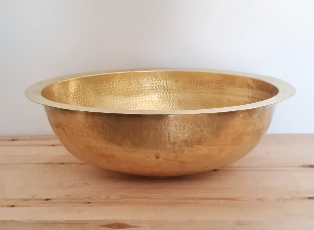 Elegant oval brass sink with a natural finish for a luxurious bathroom decor