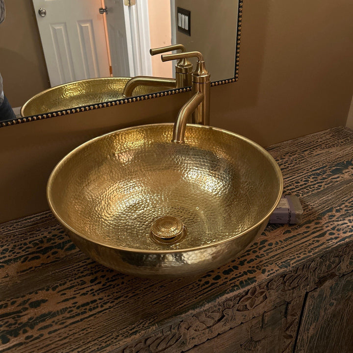 Round brass bathroom sink with a warm finish for an elegant bathroom design